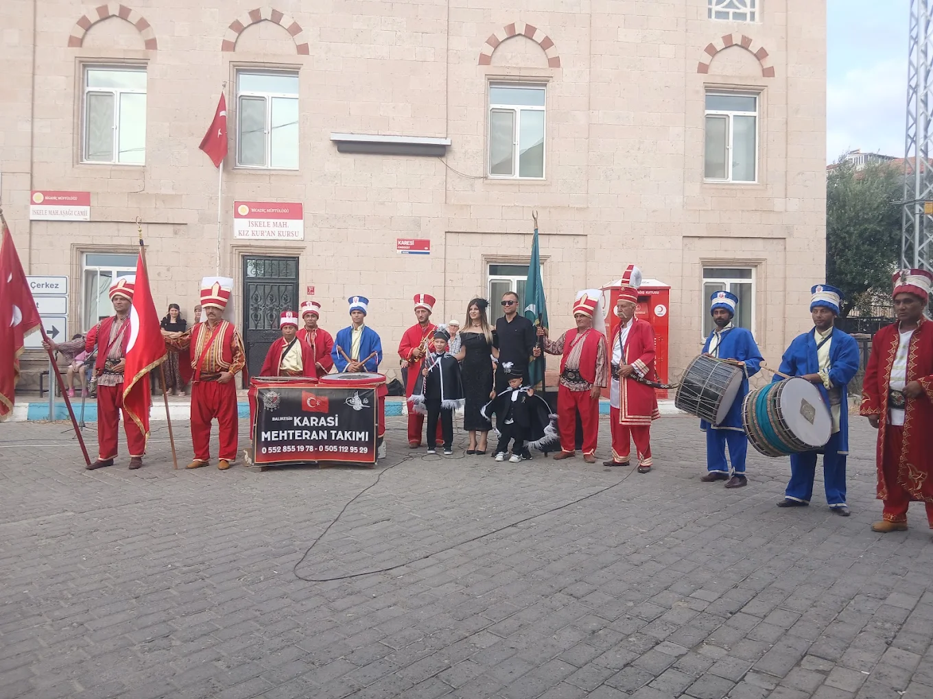 Kırmızı ve mavi kıyafetleri, davulları ve sancaklarıyla açık alanda bir araya gelen Karasi Mehteran ekibi